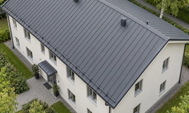 Mörkt falsat plåttak på ett flerbostadshus
